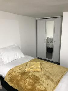 a bedroom with a bed with a gold blanket on it at Premier Property Lettings Limited in Castle Donington