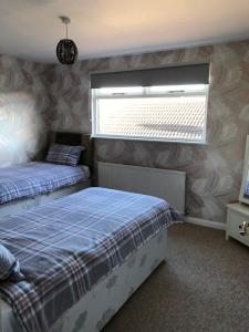a bedroom with two twin beds and a window at Number One - Fully Equipped Self Catering Four Bedroom House next to Dunedin, 15 mins to Spurn, 20 mins to Saltend, 12 mins to Easington in Patrington