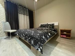 a bedroom with a bed with a black comforter with stars at Sekulic Apartments in Loznica