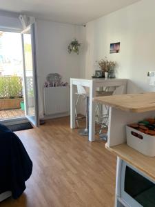 une cuisine avec une table blanche et une salle à manger dans l'établissement Super logement cosy, à deux pas du tram, à Nantes