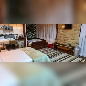 a hotel room with two beds and a brick wall at Caminhos da Serra do Tabuleiro - Chalé das Árvores in São Bonifácio