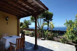 a patio with a table and a view of the ocean at Casa Los Mangos in Fuencaliente de la Palma