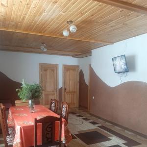 uma sala de jantar com uma mesa e uma televisão no tecto em Між Тростяном та рікою em Slavske