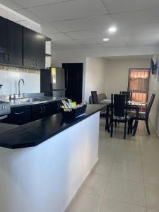 Una cocina con fregadero y una mesa con sillas. en Apartamento Ucha, en Ríohacha