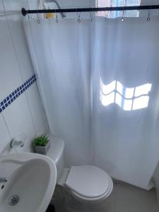 Baño blanco con aseo y lavamanos en Apartamento Ucha, en Ríohacha