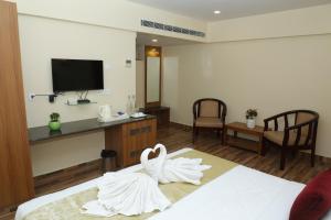 una habitación de hotel con dos cisnes sentados en una cama en Gadiraju Palace Convention Centre & Hotel en Visakhapatnam