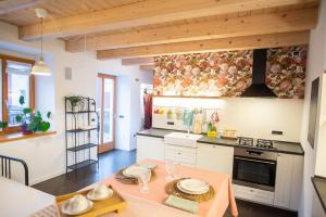 a kitchen with white cabinets and a table in a room at BeautyfoodLAB in Arco