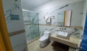 a bathroom with a toilet and a sink and a shower at Miami Inn in Nuevo Vallarta