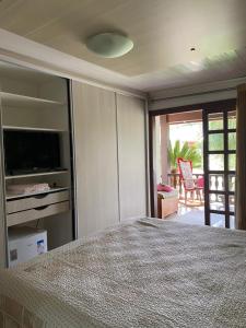 een slaapkamer met een bed, een televisie en een patio bij Suíte aconchegante in Santa Cruz do Sul