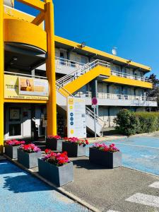 特拉普的住宿－聖昆廷伊夫林伊蘭科特普瑞米爾經典酒店，一座黄色的大建筑,前面有鲜花