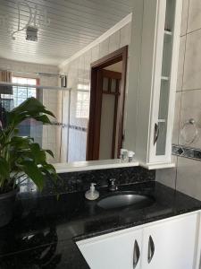 a bathroom with a sink and a mirror at Suíte aconchegante in Santa Cruz do Sul