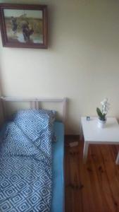 1 dormitorio con 1 cama y 1 mesa con una foto en la pared en HomeHostel, en Varsovia