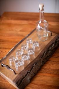 bandeja de madera con una botella y un grupo de cristales en Vista Mountain House en Kopaonik