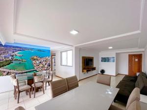 un soggiorno con un divano e un tavolo di Cobertura c/ vista para o mar e montanhas, churrasqueira, 4 quartos 2 Vg garagem a Guarapari