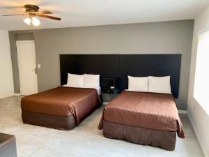 a bedroom with two beds and a ceiling fan at Tarpon Inn in Tarpon Springs