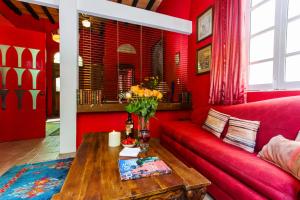 
a living room filled with furniture and a red couch at Garlands Del Rio in Puerto Vallarta
