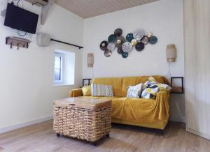 salon z żółtą kanapą i stołem w obiekcie Studio ALYA, mini-gîte en campagne de Lizio w mieście Lizio