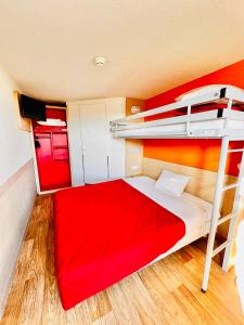 a bedroom with a red bunk bed and a ladder at Premiere Classe St Quentin en Yvelines Elancourt in Trappes