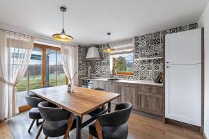 a kitchen with a wooden table and chairs and a refrigerator at Domačija Vrški in Slovenska Bistrica