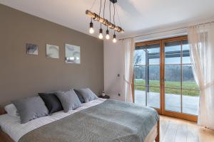 a bedroom with a large bed and a large window at Domačija Vrški in Slovenska Bistrica