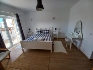 una camera con letto, scrivania e specchio di Casa Pinheirinho a Sagres