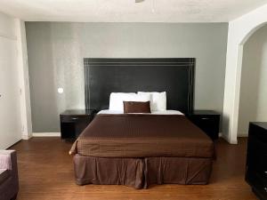 a bedroom with a large bed with a black headboard at Tarpon Inn in Tarpon Springs