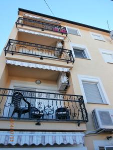 a building with a balcony with two chairs on it at Apartment Ksenija in Crikvenica