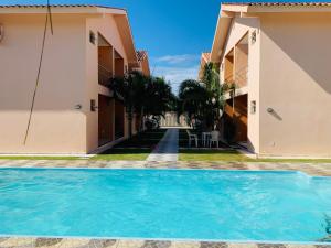 - une piscine en face de deux maisons dans l'établissement Condominio Jardim Tropical, à Porto Seguro