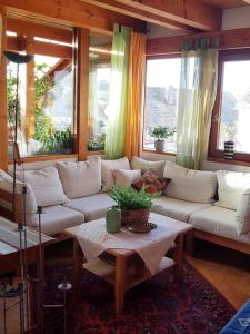 ein Wohnzimmer mit weißen Sofas und einem Tisch in der Unterkunft Zentrale Ferienwohnung auf dem schönen Hunsrück in Halsenbach