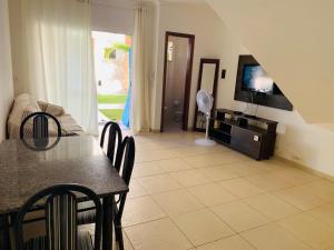 - un salon avec une table à manger et une télévision dans l'établissement Condominio Jardim Tropical, à Porto Seguro