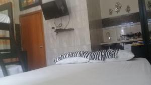 a bed with two white pillows and a television at Habitacion Vacacional Camboriu in Salinas