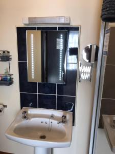 a bathroom with a sink and a mirror at Dolphin Hotel Public House Weymouth in Weymouth