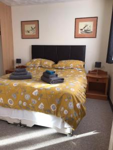 una camera da letto con un letto e un piumone giallo di Dolphin Hotel Public House Weymouth a Weymouth