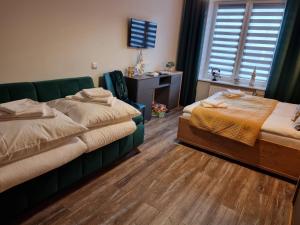 een slaapkamer met 2 bedden, een bureau en een raam bij Apartament LuxLoft in Piechowice