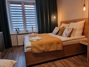 een slaapkamer met een bed met kussens en een raam bij Apartament LuxLoft in Piechowice