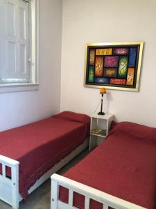 a bedroom with two beds and a painting on the wall at HABITACION PRIVADA EN EDIFICIO HISTORICO in Buenos Aires