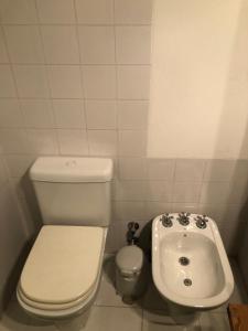 a small bathroom with a toilet and a sink at HABITACION PRIVADA EN EDIFICIO HISTORICO in Buenos Aires