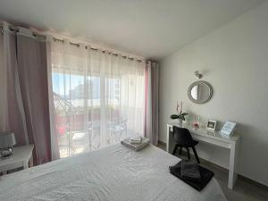 um quarto com uma cama, uma secretária e uma janela em Casa Luztour na Praia da Luz