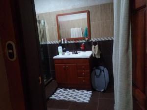 y baño con lavabo y espejo. en Casa 114, en Managua