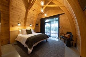 um quarto num chalé de madeira com uma cama e uma janela em Benger Garden Chalets em Millers Flat