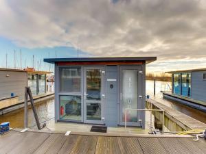 a small house on a dock on the water at Modern Houseboat in Marina of Volendam with Swimming Pool in Volendam
