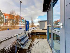 福伦丹Houseboat in Volendam near Fort Edam的建筑物旁边码头上的长椅