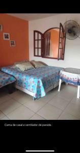 a bedroom with a large bed and a mirror at Conforto e simplicidade! Casa top com garagem, cozinha, banheiro e quarto in Cabo Frio
