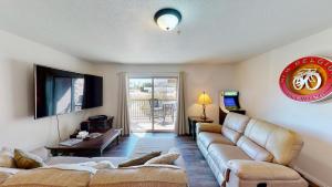 a living room with a couch and a television at Red Cliff Condos #1H in Moab