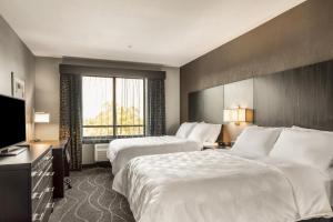 a hotel room with two beds and a flat screen tv at Holiday Inn Hotel & Suites Silicon Valley – Milpitas, an IHG Hotel in Milpitas