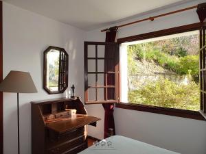 a bedroom with a window and a dresser with a mirror at LIMA COTTAGES - Casa de S Tiago in Ponte de Lima +53 photos