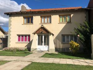 una casa con ventanas coloridas y una puerta blanca en Hospedaje Amilcar, en Esquel
