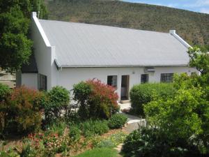 a white house with a mountain in the background at 4 Rothman Street B&B in Graaff-Reinet