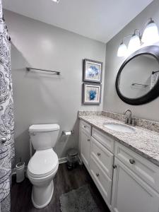 La salle de bains est pourvue de toilettes, d'un lavabo et d'un miroir. dans l'établissement Change in Attitude - 2BR Condo Golfin’, Fishin’, Beachin’ Everyday, à Edisto Island