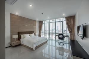 a bedroom with a bed and a large window at Maline Exclusive Serviced Apartments in Phnom Penh